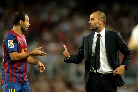 Guardiola trainer of FC Barcelona gives orders to Javier Mascherano during the spanish league match against Osasuna at the Nou Camp Stadium on September 17, 2011 in Barcelona, Spainのeditorial素材