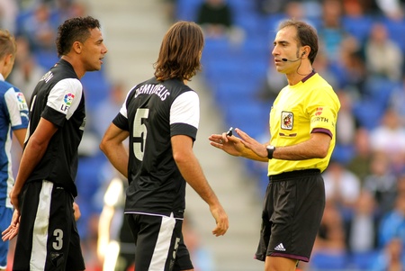 Demichelis and Welington of Malaga discuss with the referee Delgado Ferreiro during a Spanish League match between Espanyol and Malaga CF at the Estadi Cornella on October 27, 2012 in Barcelona, Spainのeditorial素材