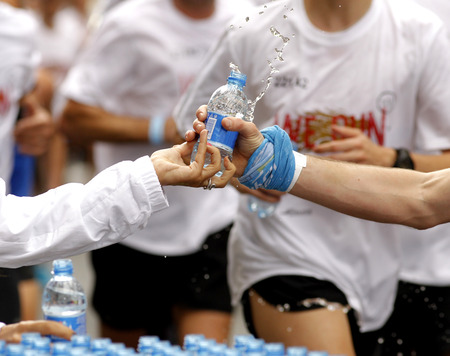 Runner take a bottle of water on a long distance raceのeditorial素材