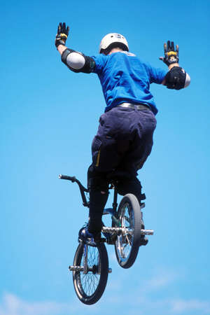 A BMX rider performs a radical no-hands trick