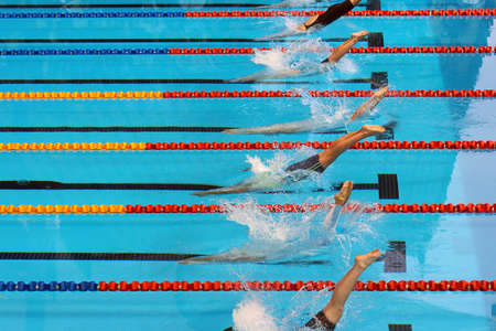 Swimmers dive into the water at the start of a race.の写真素材