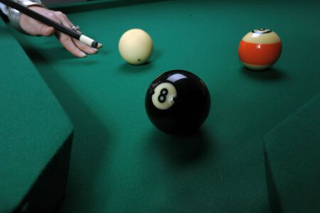 A woman hits balls on a pool (billard) table during play