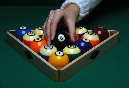 A woman places Balls on a pool (billard) table before play
