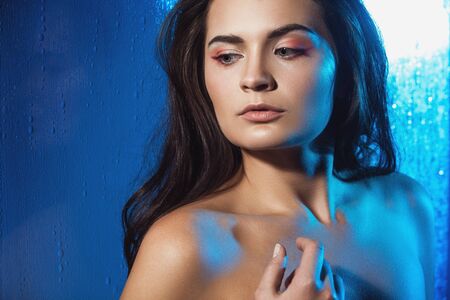 Beauty portrait of beautiful female model on a blue background. Studio shot.の写真素材