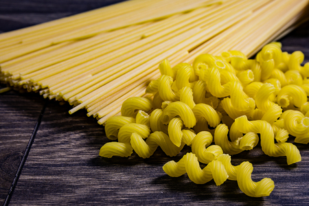Pasta from the pack on the table scattered. Macaroni is the favorite food of Italians.の写真素材