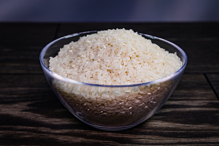 Glass bowl with rice on wooden table.の写真素材