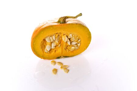 Pumpkin on a white background is cut in half. Pumpkin seeds.の写真素材