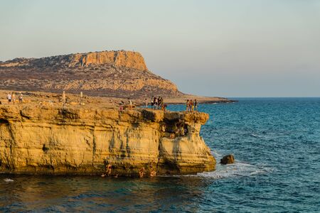 View of rocks with sea caves at sunset on Cape Greco near Ayia NAPA, Cyprus.の写真素材