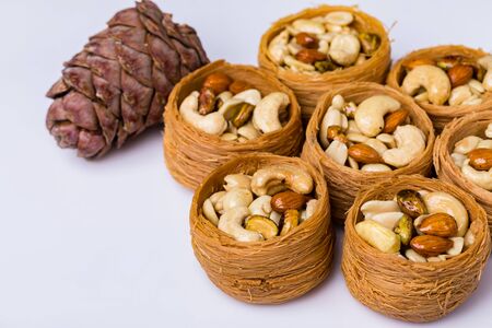 Oriental sweets, baklava, Turkish delight with almonds, cashews and pistachios on plates.