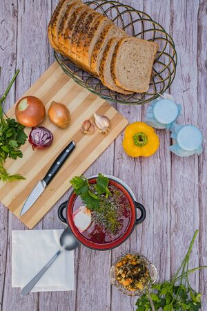 Red borsch, a national dish of Ukrainian cuisine. In the photo, borsch is a black ceramic with sour cream, green onions and garlic on a wooden background.の写真素材