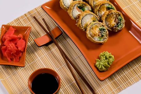 Sushi and soy sauce in a bowl and wooden sticks on the table. Japanese food. Sushi Set. Variety of rolls. Menuの写真素材