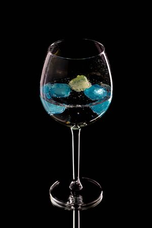 Wine glass with ice different colors on a blackの写真素材
