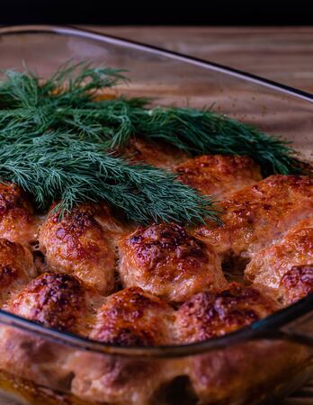 Fried meat cutlets were taken out of the oven on a baking tray on a wooden table.の写真素材