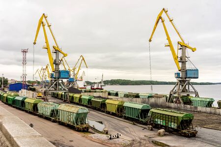 Panorama of the port cranes of ships. Railway cars on loading and unloading. The port in the city of Vyborg of Leningrad oblast, Russia.の写真素材
