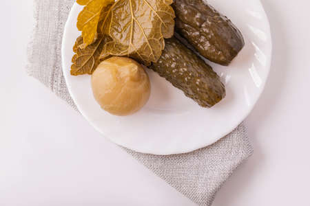Pickles on a white plate. Prepared homemade dish pickles from a jar. The concept of home cooking.の写真素材