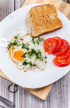 Fried eggs on a platter served with parsley and tomatoes. The concept of a delicious orange juice...