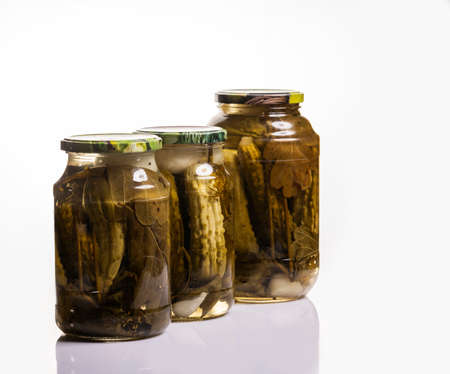 Pickles in a glass jar on a white background, canned food, picking vegetables.