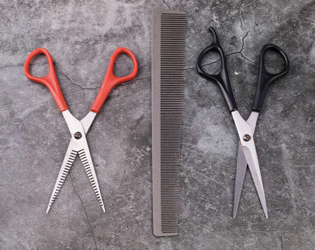 Barber tools are on the shelf in the salon. Accessories for cutting hair: scissors, combs and others are on the table.の写真素材