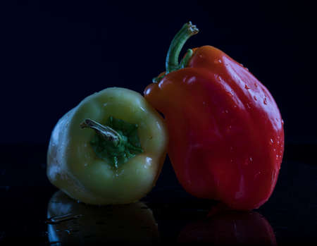 Fresh bell peppers on a black background with water droplets.