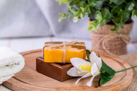 Two pieces of soap, a towel, and a white flower.Spa procedures.