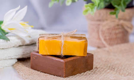 Two pieces of soap, a towel, and a white flower.Spa procedures.