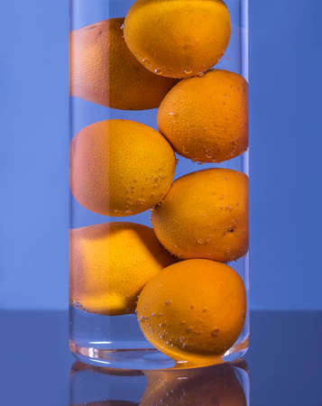 On the table is a glass glass with tangerines and sparkling water.の写真素材