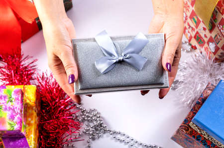 The girl is holding a gift in her hands. The concept of the new year holiday.の写真素材