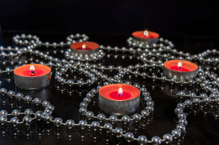 Candles and a silver garland on a glass table.の写真素材