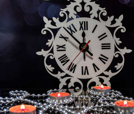 Candles and a silver garland on a glass table.