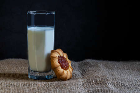 A glass glass with milk and leaning against it cookies kurabye with sweet filling.の写真素材
