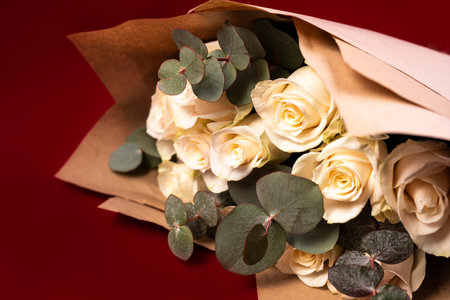 Bouquet of white roses and eucalyptus branches on a red background.の写真素材