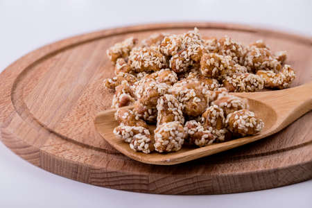 Cashew nuts in sesame seeds with honey on a wooden spoon.の写真素材