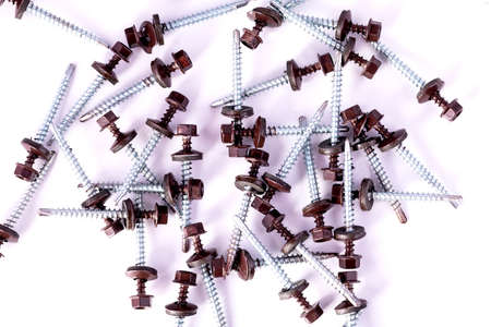 Roofing screws are scattered on the white table.の写真素材