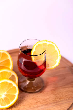 Elegant glass of red wine with a slice of lemon.