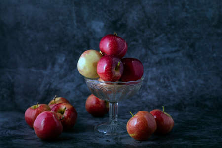 Fresh and juicy apples in a vase and on the table