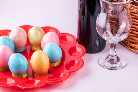 Eggs of different colors a bottle of wine and a glass glass for celebrating Easter.