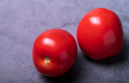 Two juicy red tomatoes on the table.の写真素材