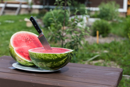 The watermelon was cut into two parts and a knife was inserted.の写真素材