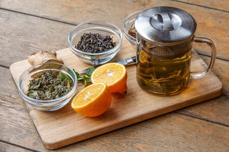 Tasty herbal tea in glass teapot on old wooden tableの写真素材