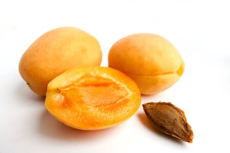 Isolated apricots. Fresh whole apricot fruit with leaf and half isolated on white backgroundの写真素材