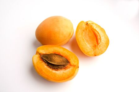 Isolated apricots. Fresh whole apricot fruit with leaf and half isolated on white backgroundの写真素材