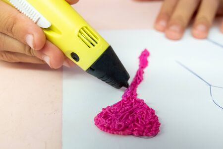 Girl uses a 3D pen to model an itemの写真素材