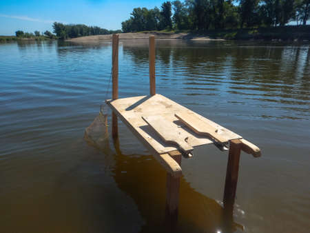table for cleaning fish from scales and cutting standing in the water for convenienceの写真素材