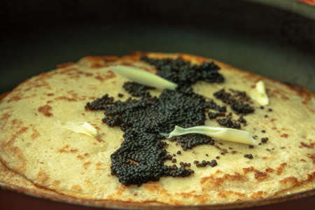 black caviar on a pancake with butterの写真素材