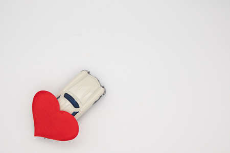 White retro toy car delivering a heart on a black and white background. Postcard February 14, Valentine's Day. Flower delivery. March 8, International Happy Women'sの写真素材