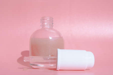 beautiful skin flat lay care pink serum liquid dropper minimal white backgroundの写真素材