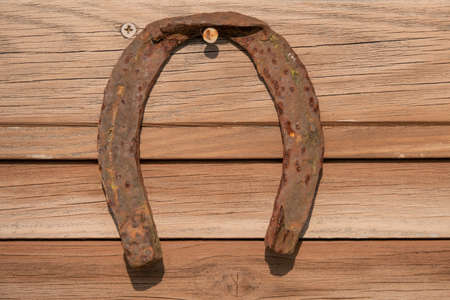 Old rusty horseshoe on vintage wooden boardの写真素材