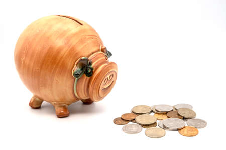 Pink piggy bank, with coins falling into slot
