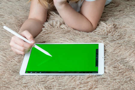 Girl digital artist draws with a stylus on a tablet or laptop. She is a student and is studying drawing.の写真素材