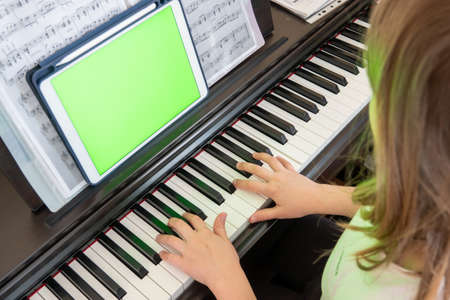 Scene of piano lessons online training or E-class learning while spread out or crisis situation, vlog or teacher make online piano lesson to teach students pupils learn from home.の写真素材